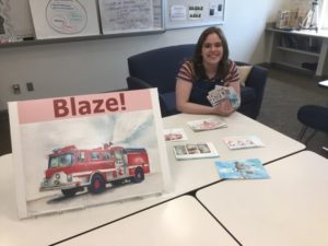 Maya Pinz '20 shows off the illustrations she created for an original board game called Blaze!