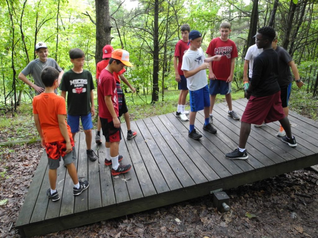 Students at Camp Wyman performing a team-based balance challenge