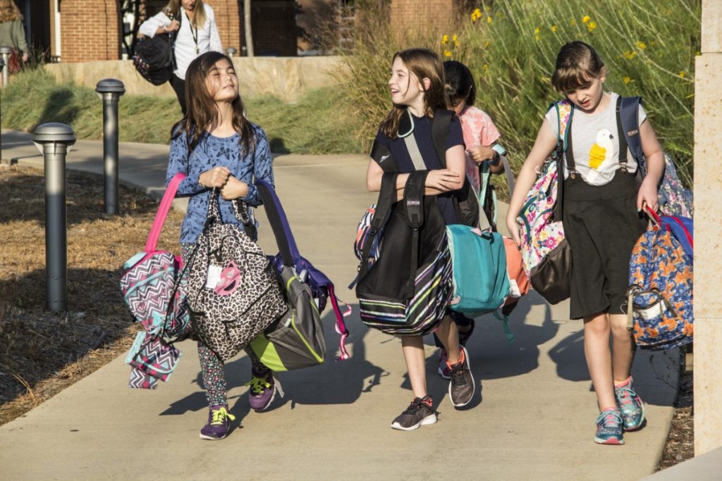 Students carry backpacks for Hurricanes Harvey and Irma relief donation drive