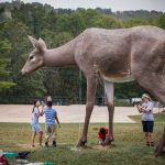 Students underneath giant deer sculpture at Laumeier Sculpture Park
