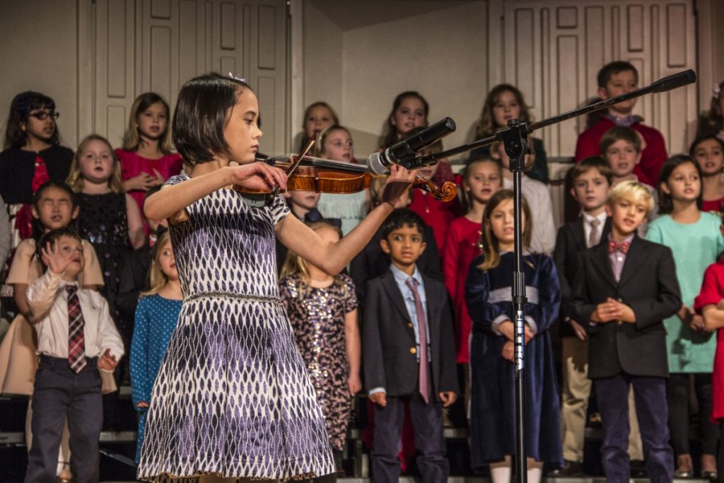 A lower schooler plays the violin for the annual Winter Program
