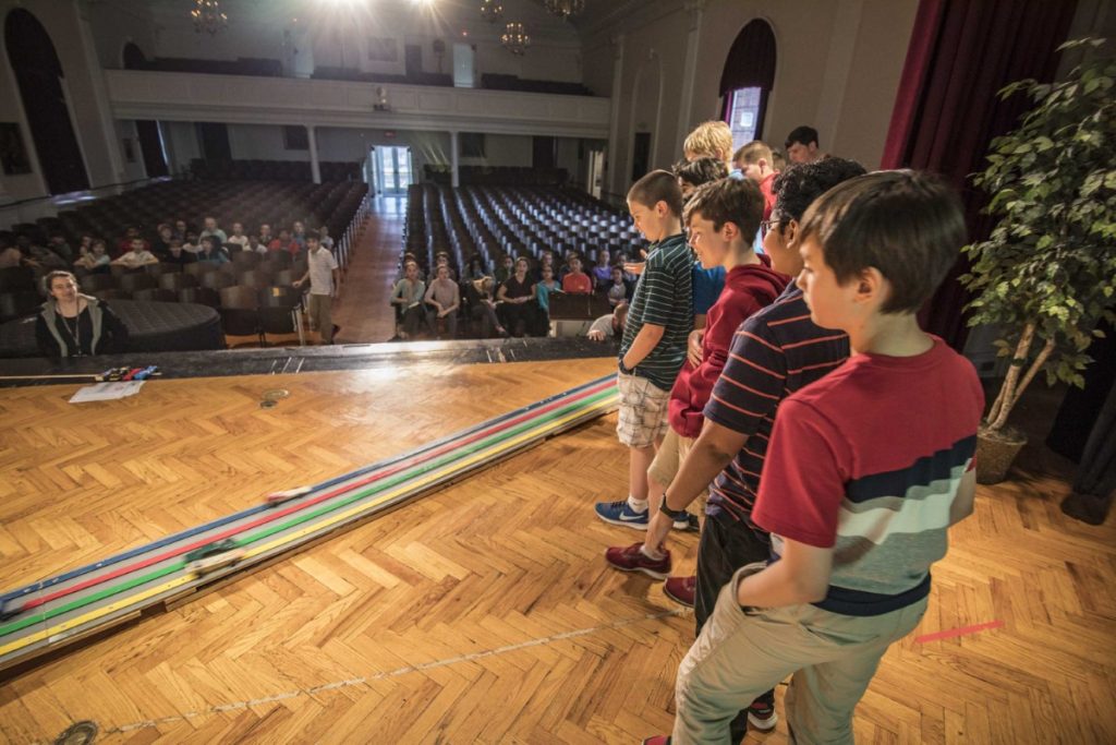 Middle Schoolers watch as their pinewood derby cars race