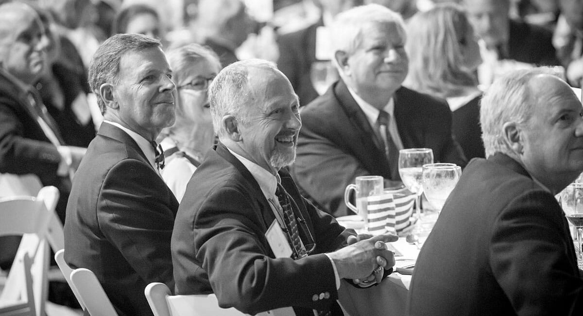Crowd shot of men smiling at CDS Centennial