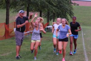 Coach Lohr high-fives track students
